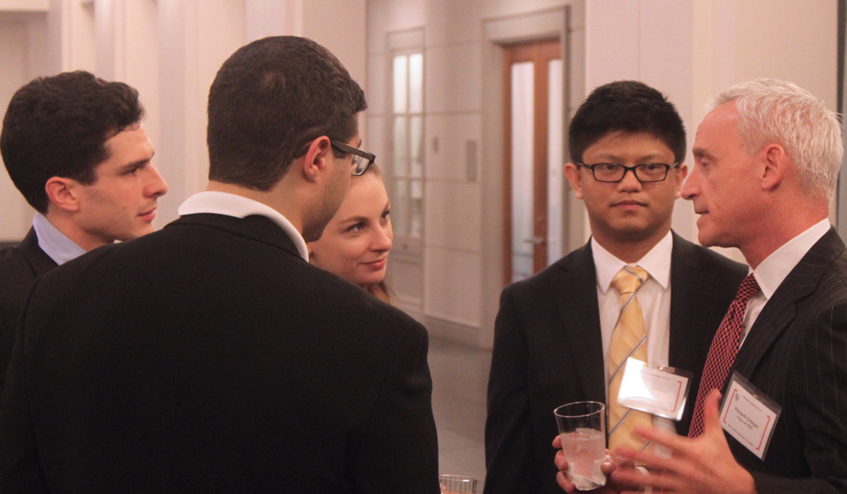 students talking to an alumnus