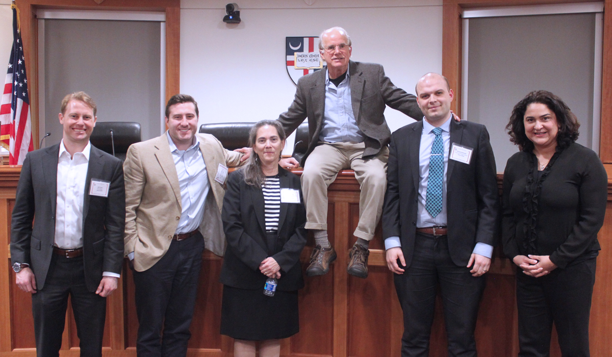 group of alumni posing for a photo in the courtroom