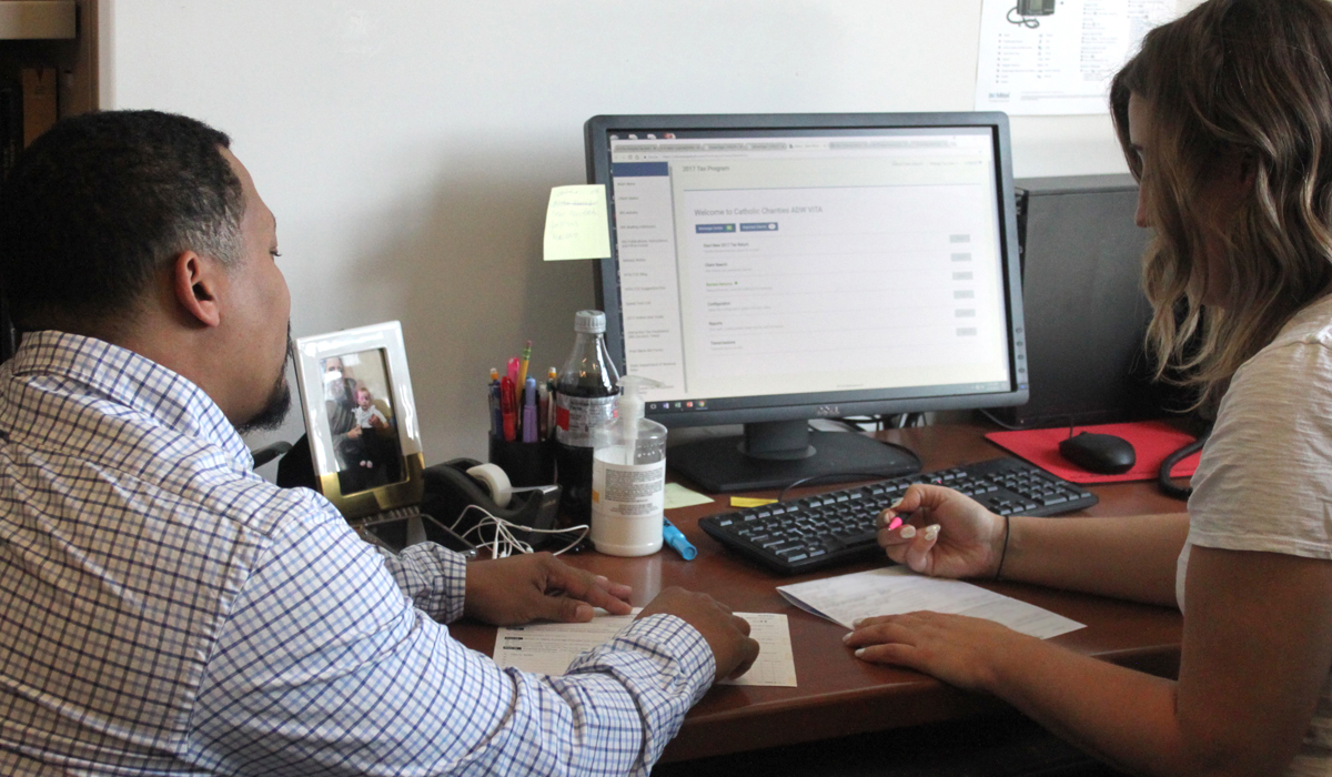 student working at desk with client