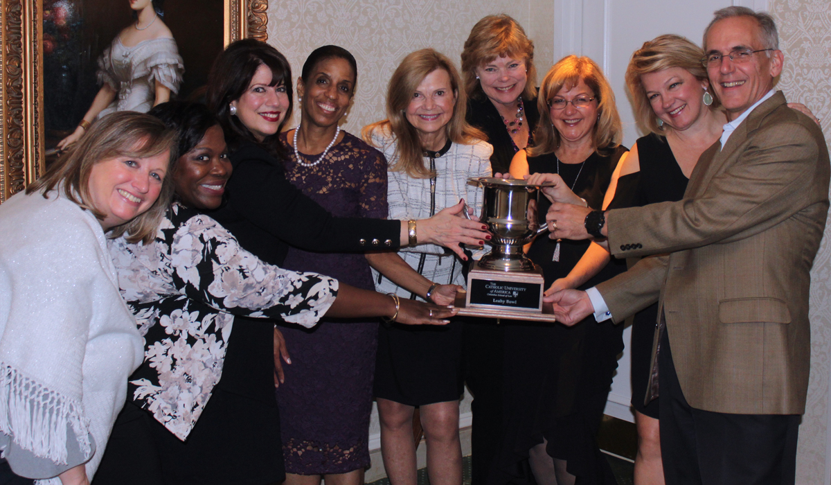 Group of alumni holding a trophy