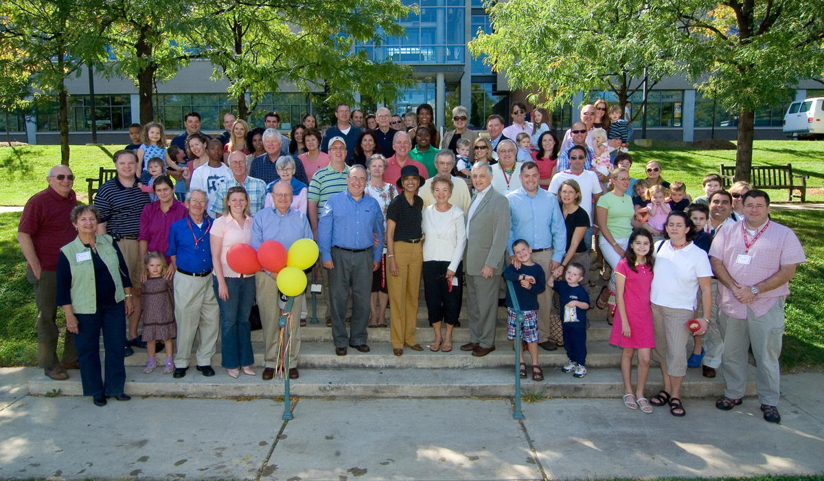 group of alumni posing for a photo in front of the Pryz