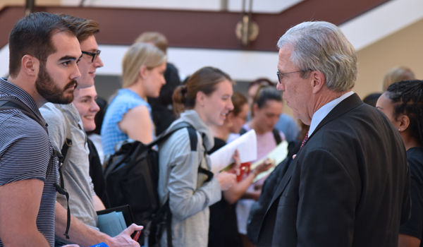 students talking to the director of the securities law program