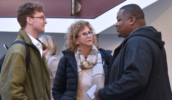 Alfred Dewayne Brown talking to a student and his parent at the reception