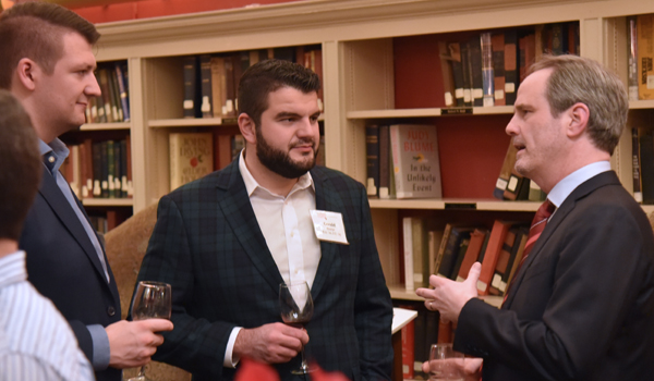 The Dean talking to two alumni