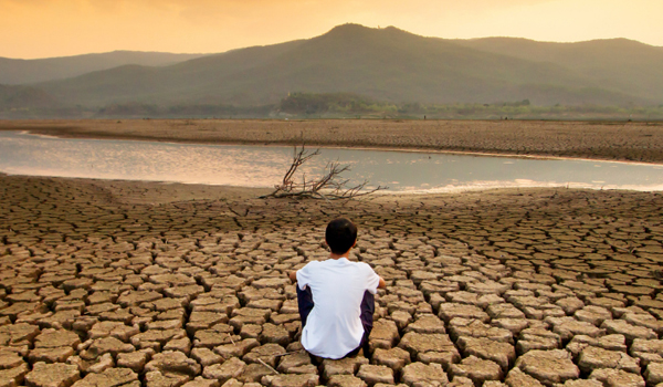 lone figure sitting in drought ravaged area