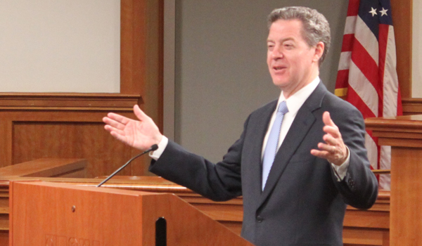 Sam Brownback speaking at podium in Slowinski Courtroom